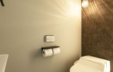 背面の壁を玄関やキッチンと合わせた壁で共通間を持たせ、間接照明で空間を格上げ。
