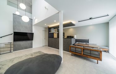 白×黒×グレーで統一されたスタイリッシュなリビング。ナチュラルクレイ調の床やウッドの家具で温かみもプラス。