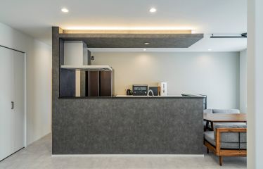 ヴィンテージメタルの美しいブラックが目を惹くキッチン。下がり天井の間接照明がオシャレな空間をさらに格上げ。