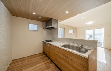 床・天井・キッチンを木目調で合わせてナチュラルに。ヘリンボーン貼りのアクセントクロスもオシャレ。