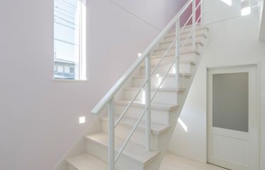 開放感あふれるオープン階段と吹き抜け。2Fホールの明るいピンクがちらりと見え、上るたびにわくわく感を演出。
