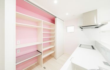 扉を開けると、ピンクのアクセントクロスが目を惹く大容量のキッチンパントリー。