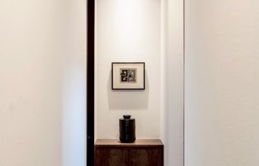 まるで小さなギャラリーのような空間。専用ライトが作品を美しく照らし、左官職人の手作業で仕上げた塗り壁の無垢な質感が、アートを自然に引き立てます。