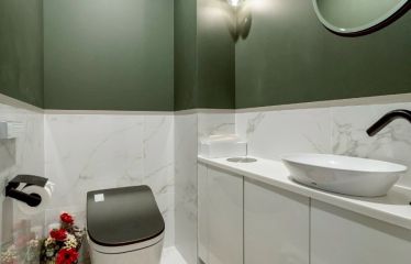 大理石調タイルとフレンチオリーブのクロスがなめらかに融合し、まるでサロンの一角。広々とした手洗いカウンターには、ダストボックスも配置。