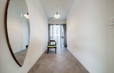 モルタル調のフロアに、塗り壁ならではの温かみが調和した、落ち着きのあるフリースペース。ロボット掃除機の”基地”もさりげなく設置。
