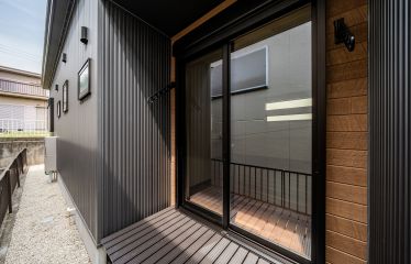 外壁と合わせて黒で統一したベランダに、木目調の外壁がアクセントとなり、重厚感のある落ち着いた印象に。