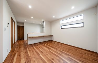 ライトグレーとウッドを基調にした、落ち着きのあるリビング。照明はすべてダウンライトで、空間全体をすっきりと仕上げました。