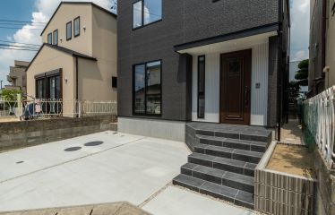 シックなチャコール外壁に、玄関周りのホワイトガルバリウムが爽やかさをプラス。