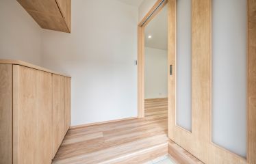 リビングと同じペカン柄の床で、玄関から室内まで心地よくつながるデザインに。シンプルながらも統一感のある空間です。