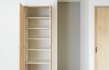 リビング収納には可動棚付きで使いやすく。隣には仏間を設け、背面にはグレージュのクロスを採用。落ち着きある空間に。