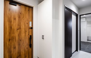 白を基調とした清潔感のある玄関ホール。やさしい木目のドアが、空間に温もりを添えます。