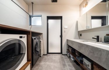 グレーを基調とした洗面室に、ウッドの棚が温かみを添えます。 アイアンの物干しや作業台を備え、洗濯の一連の作業も効率的にこなせます。