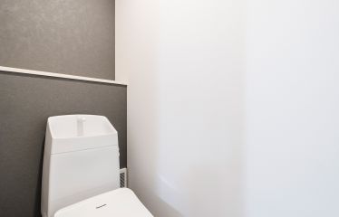 トイレは落ち着いたグレーブラウンのアクセントクロスで、空間をシックに引き締めました。