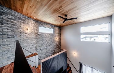 光を取り入れる吹き抜け。1階から見上げた時に、ブロック壁と天井、アイアンの手すりが美しく調和するようこだわりました。