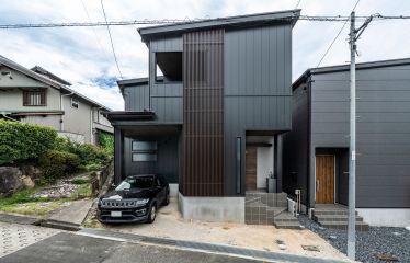 内装と統一したインダストリアルな外観。マットブラックのガルバリウムに組み合わせた木目の縦格子が、温かみと重厚感をプラス。