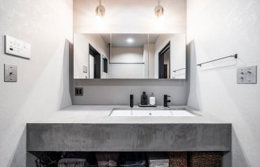 モールテックス仕上げの洗面は、リビングのヴィンテージ感を継承しつつ、明るいグレーで爽やかな印象に。