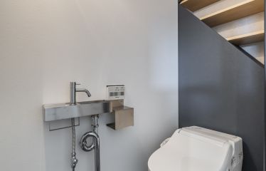 特徴的なデザイン収納が目を惹くトイレ。 むきだしの排水管もスタイリッシュに映え、 実用性とデザイン性を兼ね備えた空間に仕上がっています。