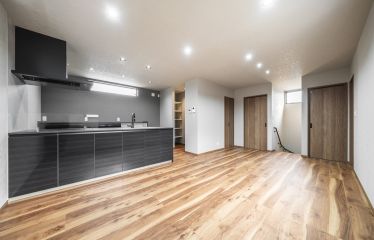 石目調のクロスで上品にまとめたリビング。ダークグレーのアクセントが、空間にメリハリをプラス。