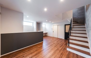 石目調のアクセントクロスがリビングに深みと表情をもたらします。あたたかなキャメルカラーの床と調和し、洗練されたカフェライクな空間に。